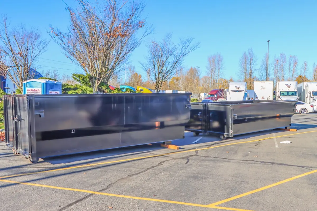 Professional dumpster rental service with roll-off container on residential driveway in Rose Hill